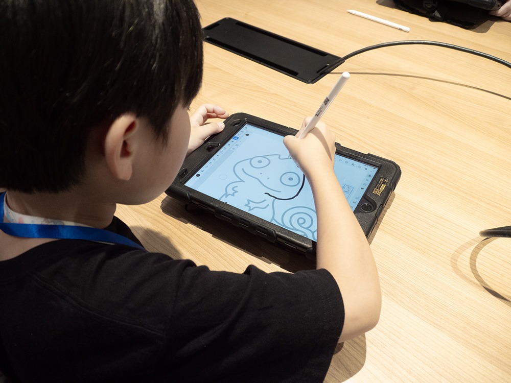 写真：子どもがタブレットで絵を描いているようす